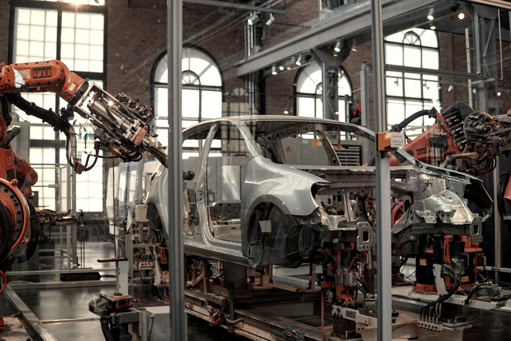 Robotic arms working on a car body in a vehicle assembly plant