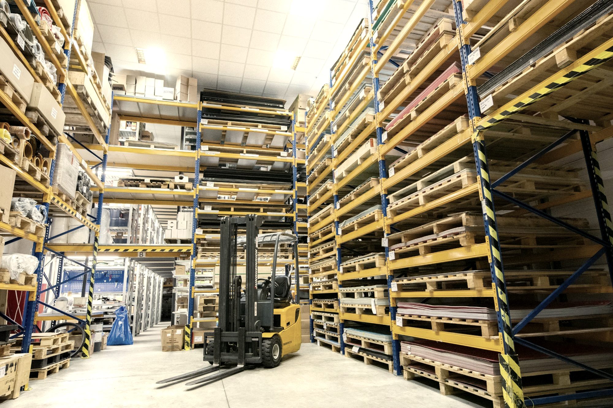 Forklift between tall racking in a distribution warehouse